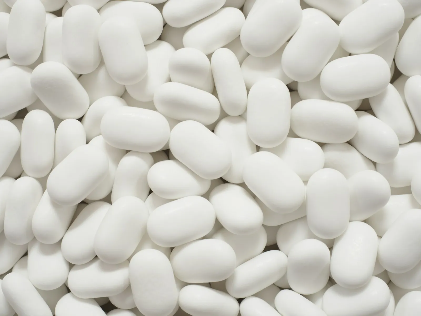 White oval tablets arranged on a plain surface